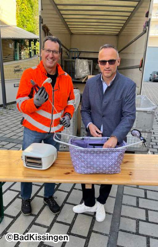 Zwei Männer, die, in Bad Kissingen, E-Schrott umladen.